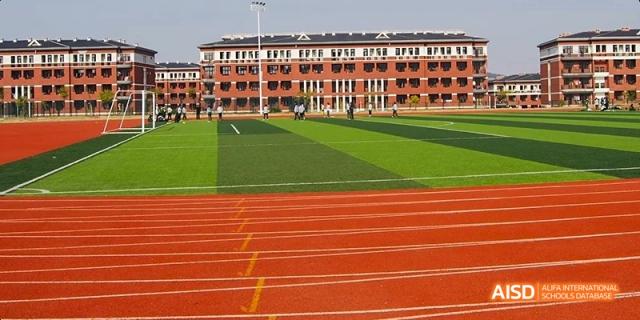 An aerial view of the athletic field with a running track at Maple Leaf International High School - Dalian.