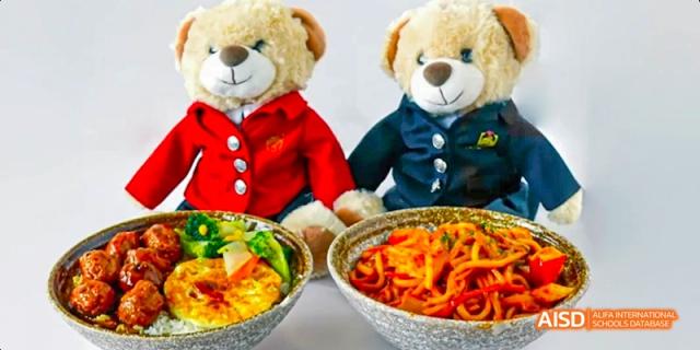 A bowl of kimchi jjigae and two teddy bears are placed on a table at Maple Leaf International High School - Dalian.
