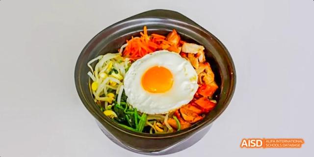 A bowl of bibimbap with a fried egg on top at Maple Leaf International High School - Dalian.