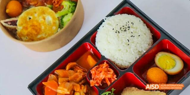 A box of bento lunch with a bowl of rice, meat, and vegetables at Maple Leaf International High School - Dalian.