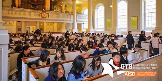 A large group of students attending a lecture in an auditorium at Beijing Aidi School.