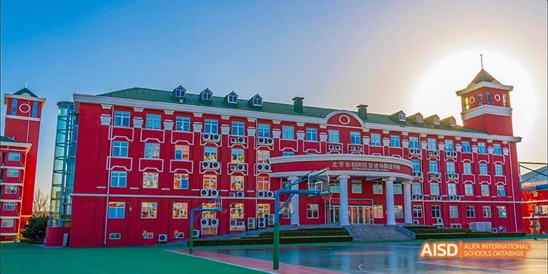 Beijing Aidi School, a view of the main red academic building with a basketball court in the foreground