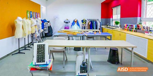 The interior of an art or design classroom at Beijing Aidi School, with tables and various items on display.