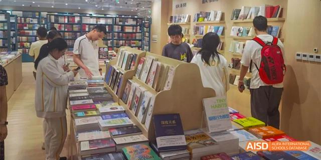 Students browsing bookshelves in the Beijing Aidi School bookstore.
