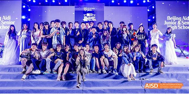 A large group of Beijing Aidi School students and staff posing for a photo on a stage.