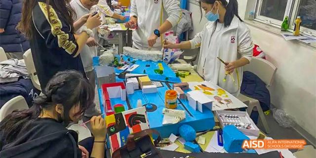 A classroom or workshop at Beijing Aidi School with tables full of various projects and materials.