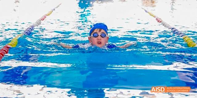 A student from Beijing Aidi School wearing goggles and swimming in a pool.