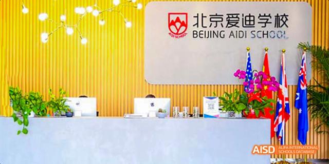 A welcome desk with a banner for Beijing Aidi School.