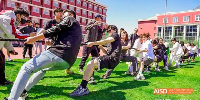 Beijing Aidi School students playing tug of war during an outdoor team-building event.