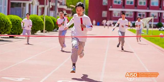 A student from Beijing Aidi School crosses the finish line during a running race.