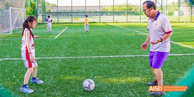 A close-up view of a soccer ball on a green field at Beijing Aidi School.