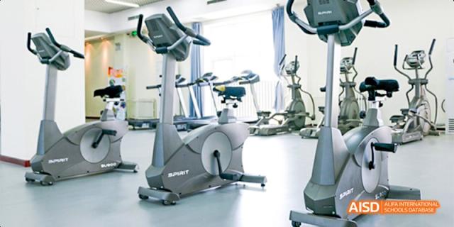 The fitness center at Beijing Aidi School, with stationary bicycles and other exercise equipment.