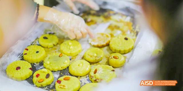 Students at Beijing Aidi School participating in a baking class, making mooncakes.