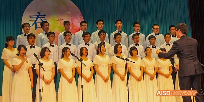 Beijing No.8 High School students perform in a choir, with young men and women singing on a stage.