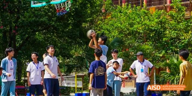 Beijing No.8 High School students playing basketball outdoors, with one student attempting a shot.