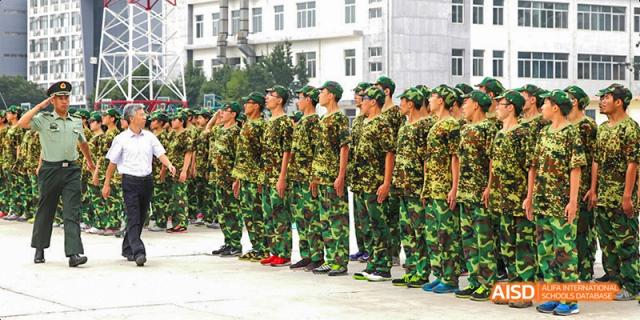 A line of Beijing No.8 High School students in camouflage uniforms standing in formation outdoors.