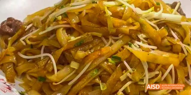 A close-up shot of a finished dish of stir-fried noodles and vegetable strips from a Beijing No.8 High School culinary activity.