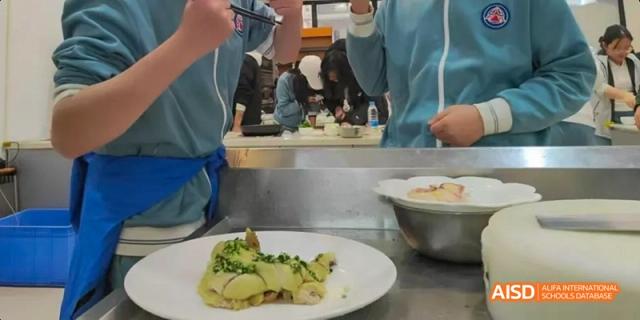 A Beijing No.8 High School student serves a chicken dish onto a white plate with other students in the background.