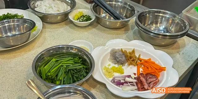 Ingredients neatly arranged in bowls on a table for a dish, including green onions and colorful garnishes, for Beijing No.8 High School students.