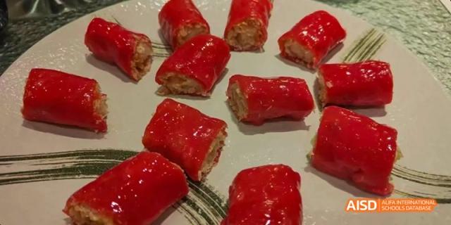 A plate of bright red, bite-sized savory rolls, likely from a cooking class at Beijing No.8 High School.