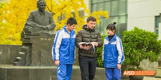 Chengdu Shishi High School Beihu Campus AP Curriculum students talking with a teacher outside.