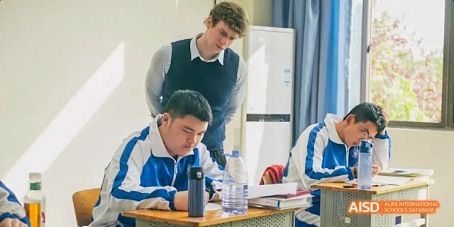 Chengdu Shishi High School Beihu Campus AP Curriculum student receiving one-on-one help from a teacher.