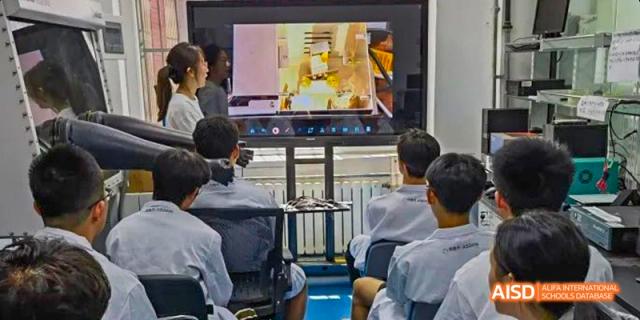 Chengdu Shishi High School Beihu Campus AP Curriculum students attend an assembly or presentation in a gym.
