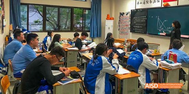 Chengdu Shishi High School Beihu Campus AP Curriculum students working together on a project in a classroom.