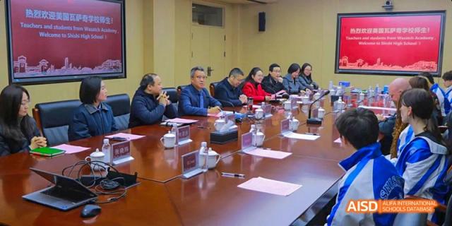 Adults and faculty from Chengdu Shishi High School Beihu Campus AP Curriculum sit at a conference table during a meeting.
