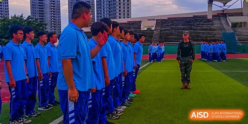 Chengdu Shishi High School Beihu Campus AP Curriculum students in blue uniforms standing in formation on a sports field.