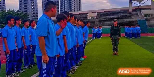 Chengdu Shishi High School Beihu Campus AP Curriculum students in blue uniforms standing in formation on a sports field.