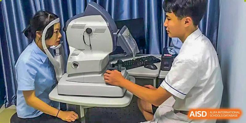 Chengdu Shishi High School Beihu Campus AP Curriculum student practicing using an eye exam machine for optometry training.