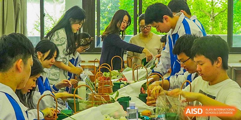 Chengdu Shishi High School Beihu Campus AP Curriculum students and faculty gathered around a food display at an event.