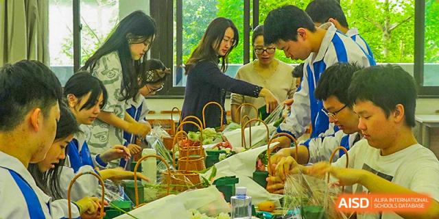 Chengdu Shishi High School Beihu Campus AP Curriculum students and faculty gathered around a food display at an event.