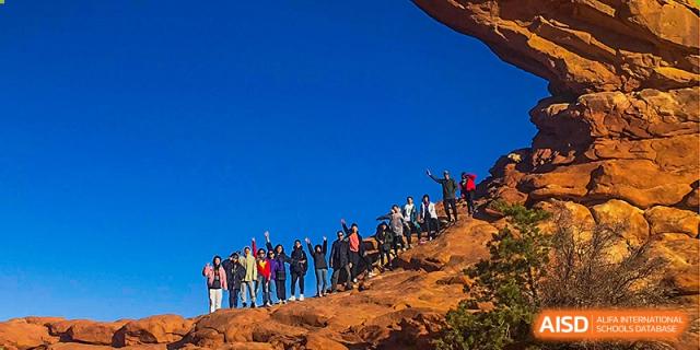 Chengdu Shishi High School Beihu Campus AP Curriculum students hiking a rocky mountain trail.