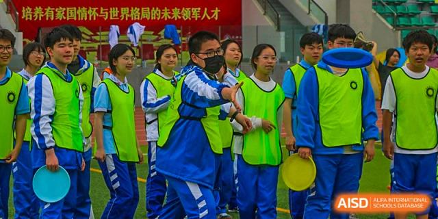 Chengdu Shishi High School Beihu Campus AP Curriculum students at a school sports event, some wearing blue and some wearing green uniforms.