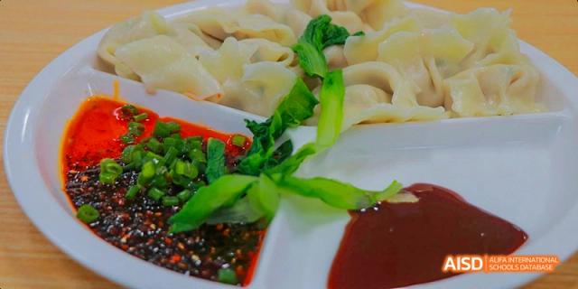 Chengdu Shishi High School Beihu Campus AP Curriculum students eating dumplings with dipping sauce.