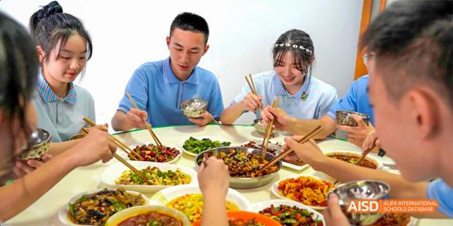 Chengdu Shishi High School Beihu Campus AP Curriculum students eating a meal together with chopsticks.