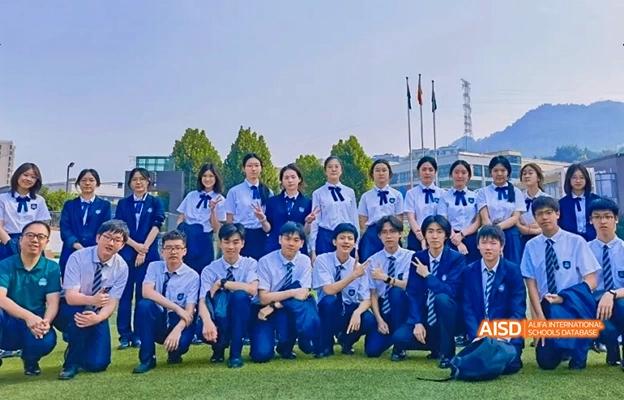 A large group of students posing for a photo on a grassy field at Chongqing Depu Foreign Language School