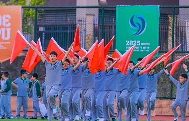 A group of students marching and holding red flags at Chongqing Depu Foreign Language School