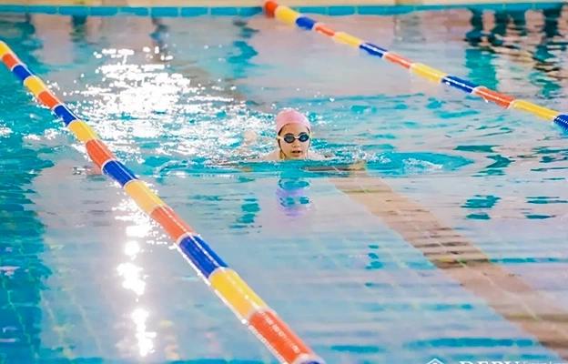 A student swimming in an indoor pool at Chongqing Depu Foreign Language School