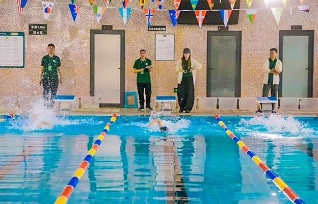 Students and a teacher by an indoor swimming pool at Chongqing Depu Foreign Language School