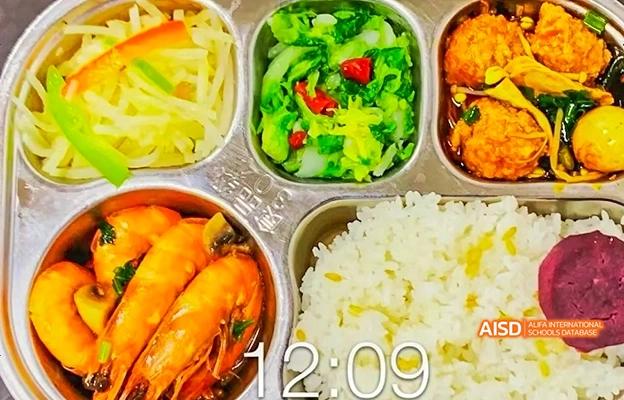 A meal tray with rice, shrimp, and green vegetables at Chongqing Depu Foreign Language School