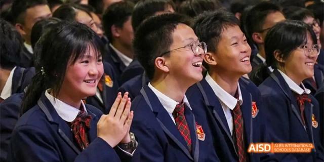 A close-up shot of several smiling high school students in their formal uniforms, attending an assembly or event at DongGuan Laguna Verona Foreign Language School.