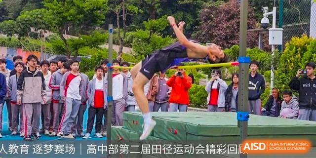 An athlete performing a high jump or back flip over a mat during a sports competition at DongGuan Laguna Verona Foreign Language School.