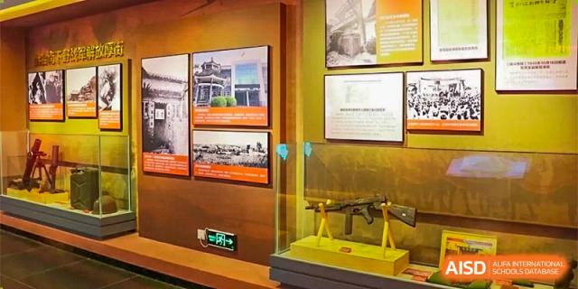 An indoor gallery or exhibit area with framed photos and historical documents displayed on warm-toned walls at DongGuan Laguna Verona Foreign Language School.