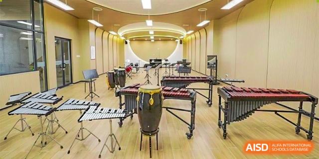A well-lit music rehearsal room featuring a variety of large percussion instruments, including marimbas and timbales, at DongGuan Laguna Verona Foreign Language School.