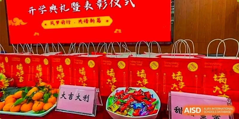 A close-up of several bright red gift bags and a bowl of candy, likely prizes or gifts for an event at GDUFS International School Guangzhou.