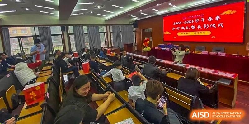 An indoor view of a lecture hall or classroom where students and adults are seated, participating in a lesson or meeting at GDUFS International School Guangzhou.