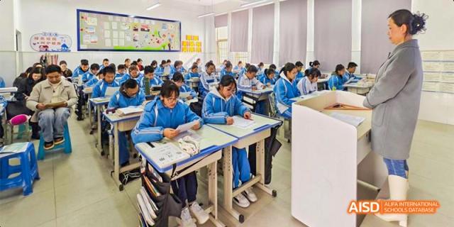 Guiyang Prime School students in blue uniforms seated at their desks, focused on taking a test or doing classwork.